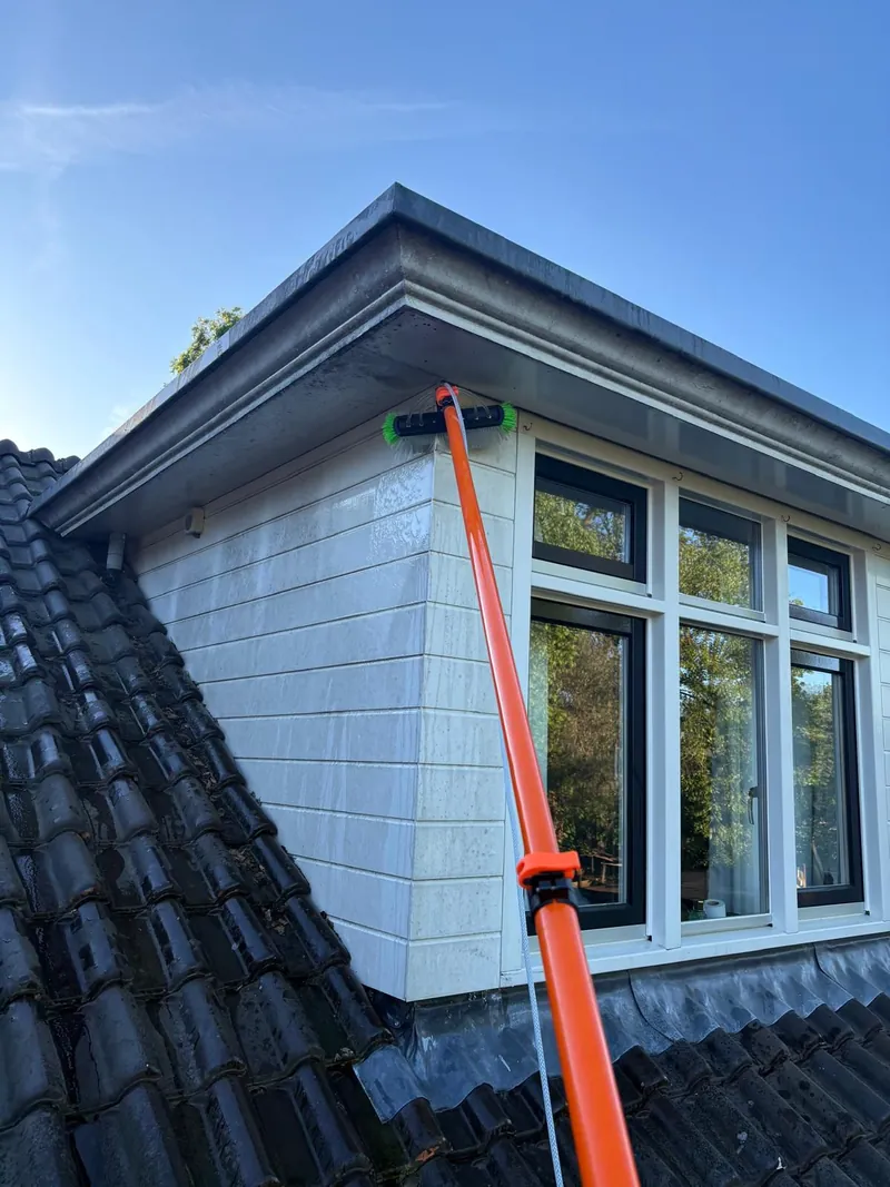 A brush on a telescopic pole at dormer windows.